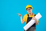 A young man wearing a hard hat and glasses, confidently holding a blueprint in a construction setting.