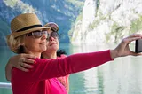 Two women in 50s standing by scenic beauty together taking a selfie together