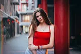 young woman with sad look , in red top