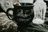 A black cup that reads ‘Witches’ Brew’.