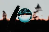 A reflective sphere with a blue tint reflecting the world upside down