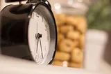 An alarm clock beside a jar of cookies