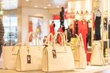 Display of off-white handbags in what looks like a department store