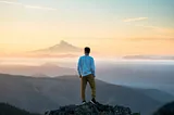 man standing on top of mountain