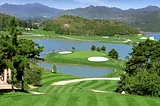 A well-manicured golf course with white sand bunkers.