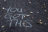 Chalk writing on pavement which reads, “You got this”.