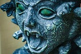 An extreme close-up of a stone stature of Medusa.