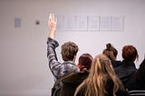 A crowd places bids at an auction on an unseen item of unknown value.