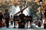 Rear view of a man playing piano in an outdoor park.