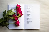 A bundle of roses laying on a book of poems