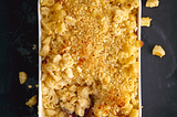 Overhead shot of a casserole dish full of baked macaroni, crispy breadcrumbs on top.