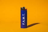 The white Lighter Curse stuck around for a reason by nicole wallet. This photo is of a blue BIC lighter with the letters FAMT on the side. Orange background