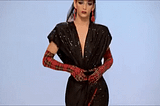 GIF: Drag queen Violet Chachki on RuPaul’s Drag Race walking a runway and revealing a red garment from under a black one