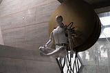 Sculpture of a humanoid robot suspended in mid-air.