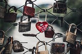 Chain link fence with multiple padlocks attached to save secrets