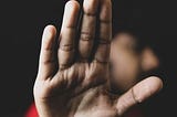 A man holding up his palm to the camera.