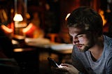 Man sitting down to text at night
