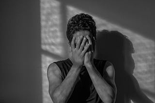 Person covering their hands with their face