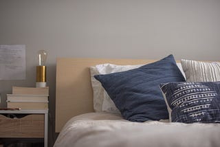 A made bed with throw pillows