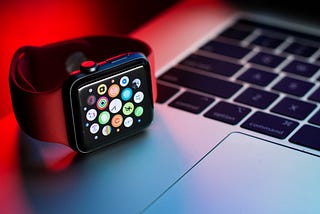 an apple watch sitting on a macbook keyboard