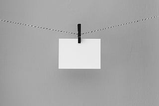 A blank white card is being held on a hanging line by a clip