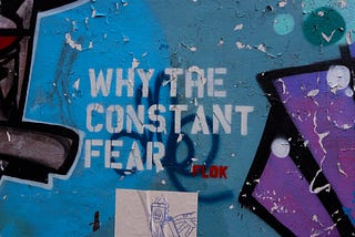 worn Graffiti  that says: Why the Constant Fear. Story: Fear Inventory by Rena Willis