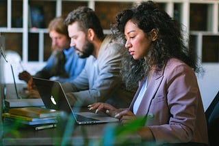 Three business leaders developing their skills and working in an office