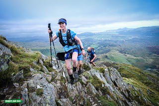 Alice climbing up a rocky mount in Wales, with the other participants following her.