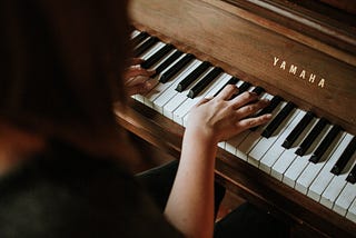Girl playing a Yamaha piano