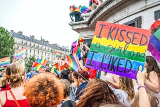 A rainbow pride flag coloured banner, with “I kissed a girl and I liked it” written on it.
