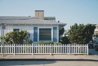 House with white picket fence and blue sky