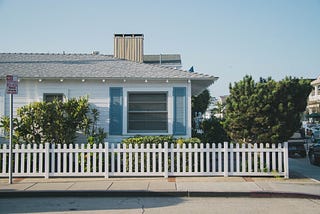 House with white picket fence and blue sky