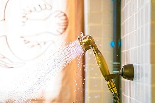 water spraying out of a showerhead, in the style of dark gold and light blue, recycled material murals, body extensions, vibrant color scheme