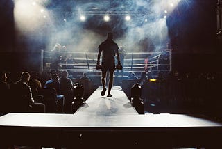 smoky, dark space with a boxing ring in the middle