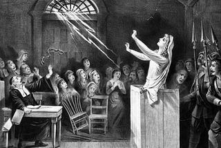 Black and white drawing of woman on the stand during the Salem Witch Trials.