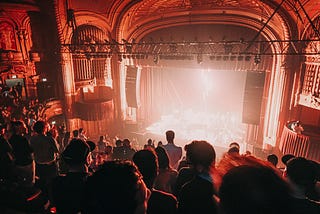 A beautiful theater with the audience clapping.