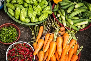 Baskets of cucumbers, carrots, okra, and herbs