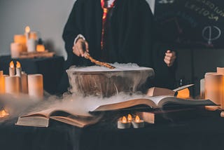 A smoking pot in which a magic potion is being created on a table with books.