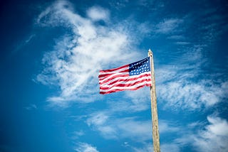 An American flag waving against the sky.