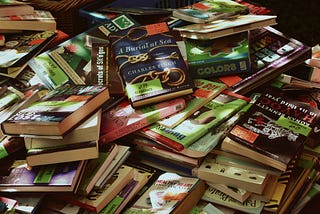 A table with a stack of unorganized books