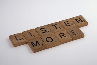 “Listen More” spelled out in Scrabble tiles.