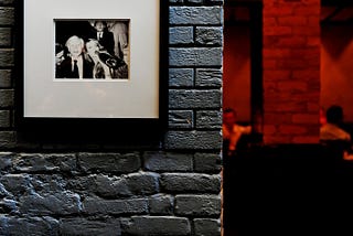 Some framed photographs on a brick wall