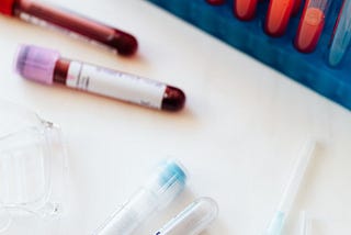 Image of blood samples in a vial and syringe on a table.