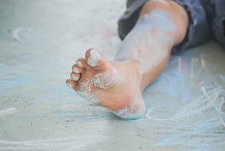 A boy’s foot smudged in colored chalk
