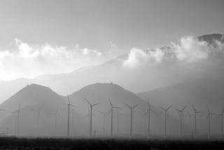 A long shot of windmills with range of mountains in the background