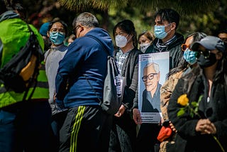 Masked protesters carry an image of Vichar Ratanapakdee, a Thai immigrant killed in an unprovoked attack by a 19-year-old man in San Francisco on January 28, 2021