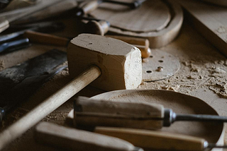 a wooden hammer and chisel on top of a workstation