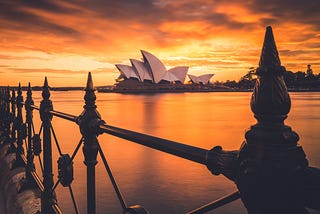 The Sydney Opera House set on a bright orange sky at dusk