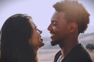 A couple happily smiling at each other.