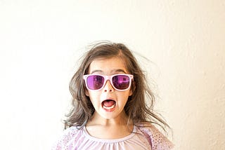 little girl surprised face wearing sunlgasses